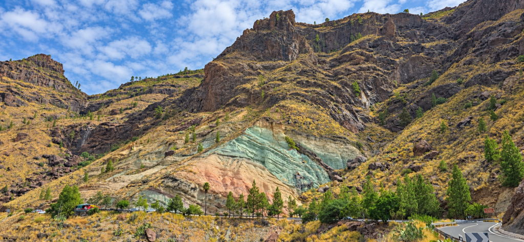 Green and ochre rock layers on a mountain slope in Gran Canaria.